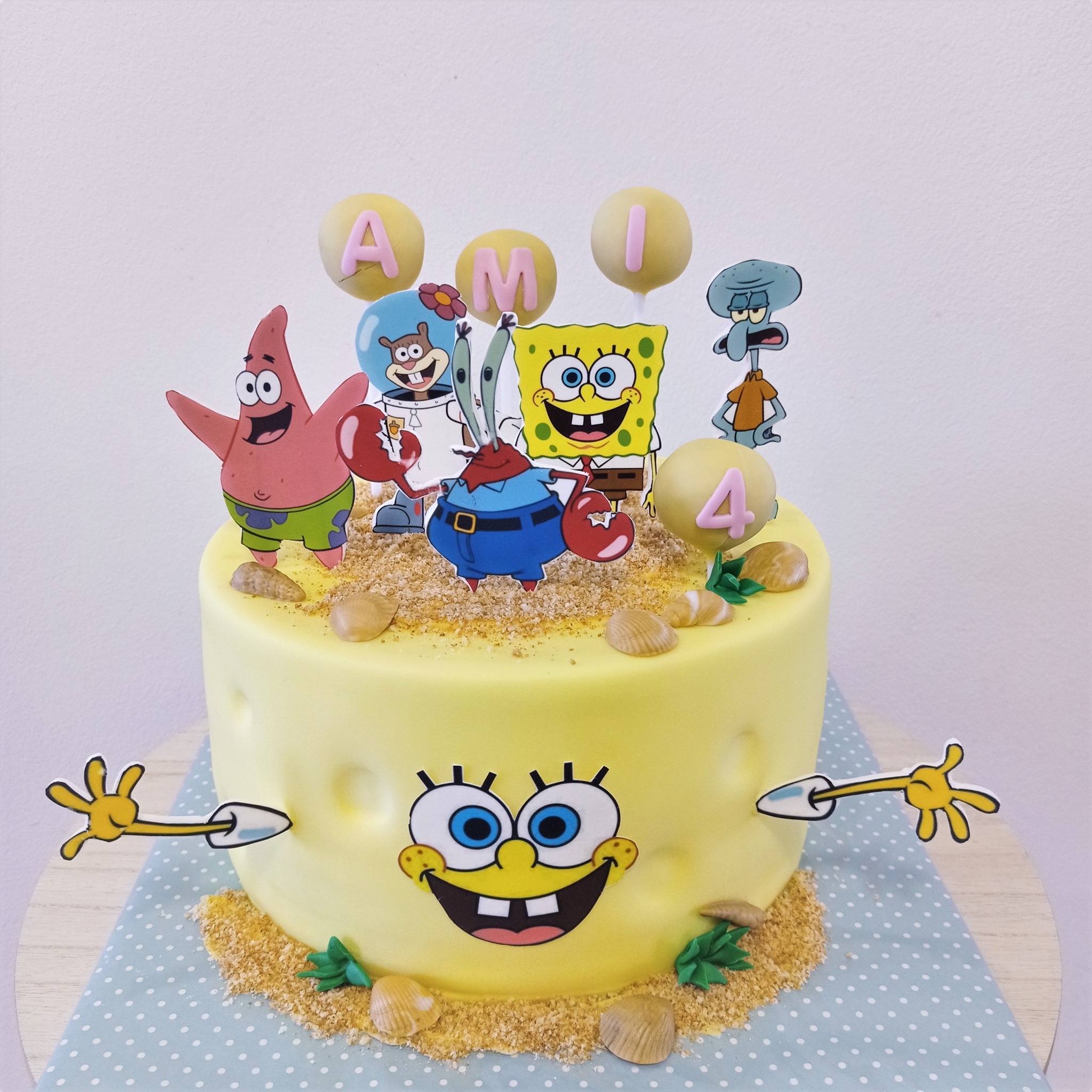 Žlutý bezlepkový dort ve tvaru Spongeboba, postavičky Patrik a Sépiák, jedlý písek, jméno Ami.